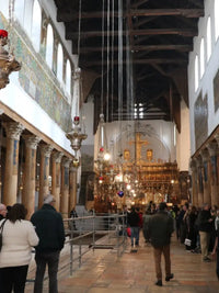 Bethlehem Church Tour Groups Interior of a large cathedral with people walking around, high ceilings, and religious architecture.